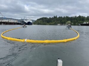 2 Boats create a U-shape in the water with boom during a exercise