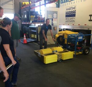 Cooperative Marine Mechanic demonstrates the workings of a groove drum skimmer during a tour of the Clean Rivers Cooperative Facility for the NOAA Science of OIL Spill Class tour.