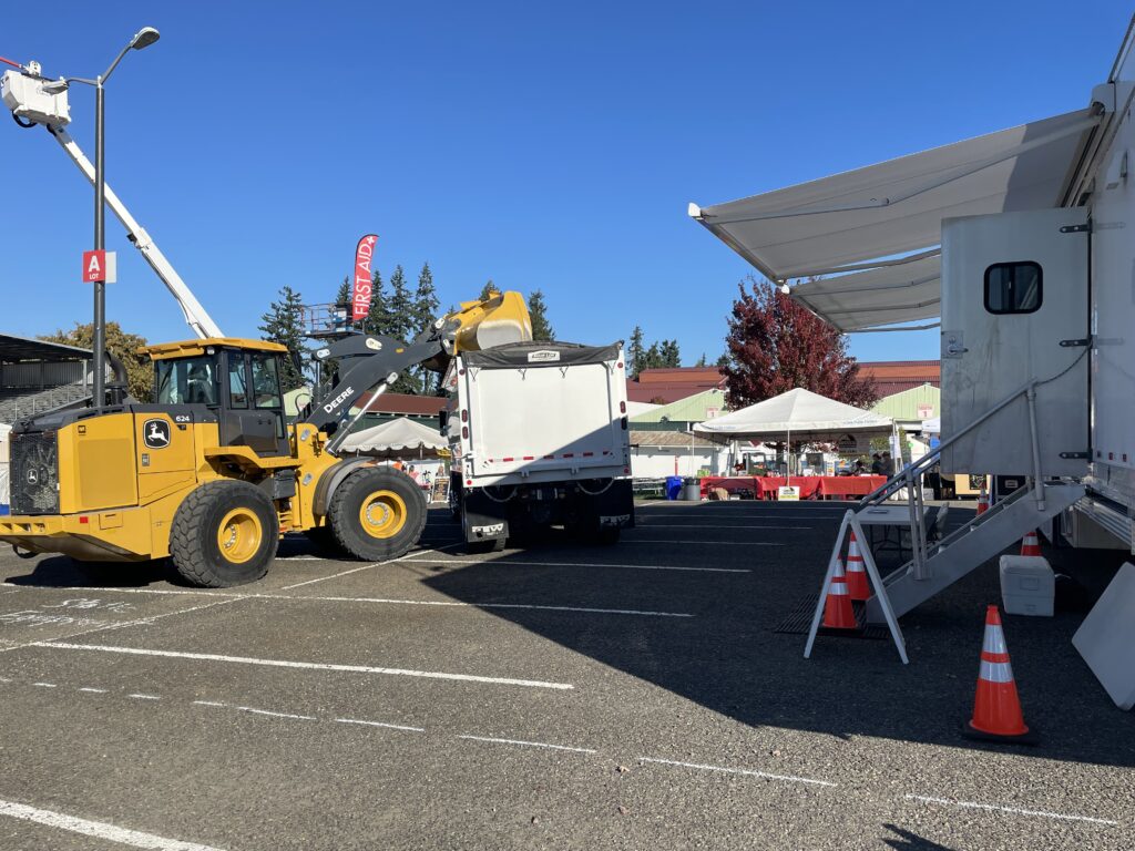 Clean Rivers Cooperative Mobile Command and Communications Trailer set up at DOZER DAY at Clark County Fairgrounds. Pictured with backhoe, dump truck and boom lift.
